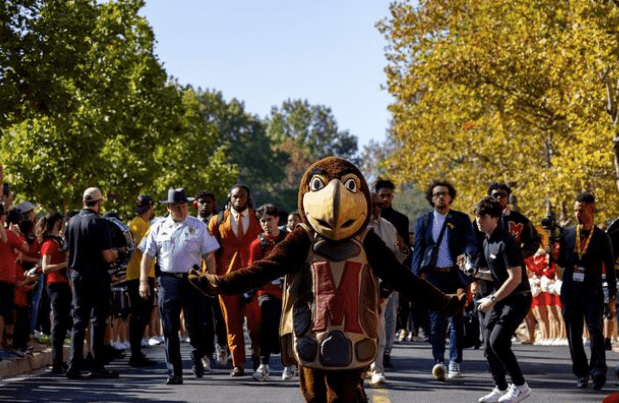 testudo walking on a street with a crowd in the background